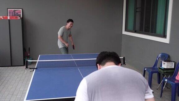 两个朋友在家里打乒乓球
