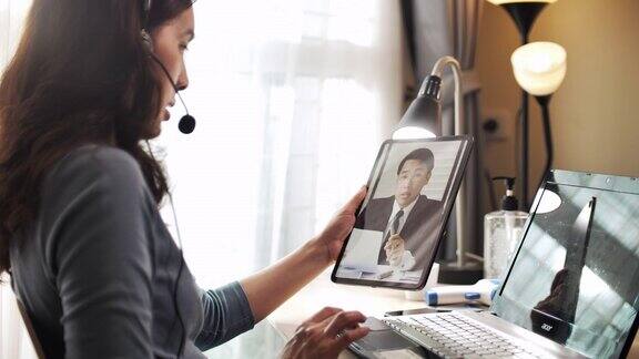 亚洲女商人在家里用数字平板电脑与她的老板进行视频通话