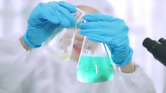 年轻的女科学家在实验室做化学实验女科学家正在小瓶中混合试剂