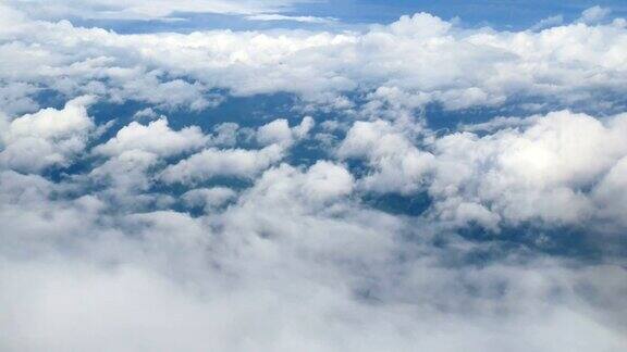 4k从飞机窗口鸟瞰美丽的白云在蓝天的背景乘飞机旅行