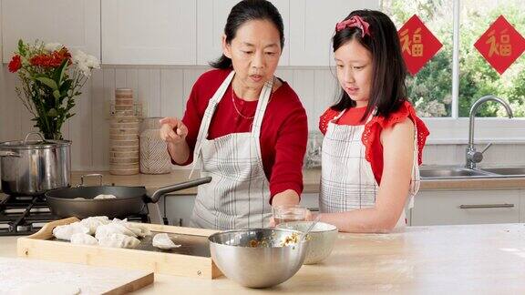 母亲学习和家庭烹饪在亚洲家庭厨房准备午餐食物和课程亚洲家庭帮助和母亲教十几岁的女儿在香港的房子饺子食谱