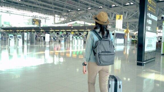 一位亚洲女旅客在机场候机楼走着