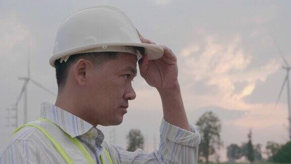 近距离面部工程师亚洲人在一个风车场工作的帽子