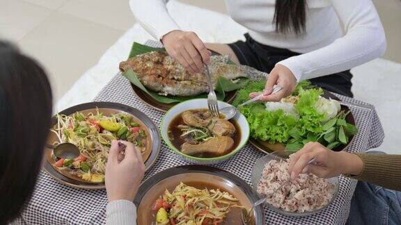 一群亚洲女性朋友坐在一起吃传统的亚洲食物如泰国当地食物的特写