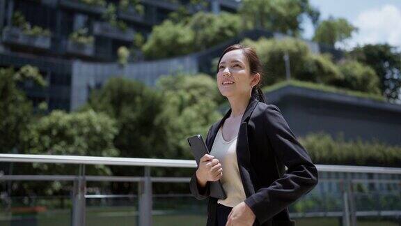 自信的商业女性穿着黑色衣服走到宽敞的公司大楼里开会