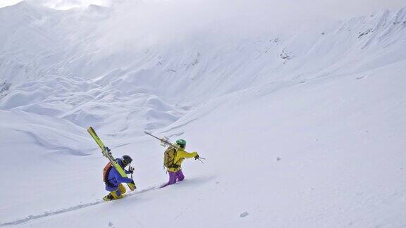 两个在野外滑雪的人正往山上走
