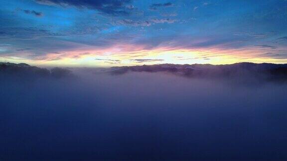 无人机飞越风景蓝色日落云景与明亮的彩色地平线4K