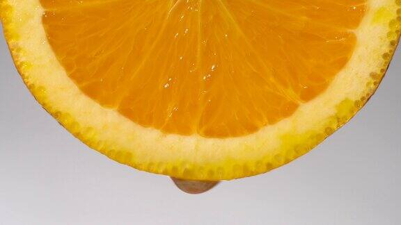 实时:水滴从橙色切片上滴到白色