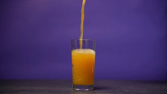 把橙汁倒进玻璃杯里