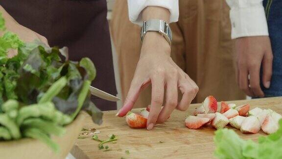 用手把草莓切成薄片放在砧板上