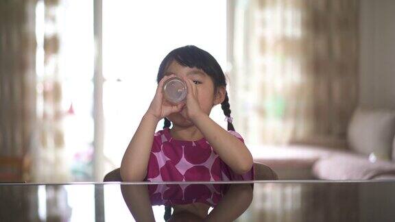 小女孩喝着一杯牛奶