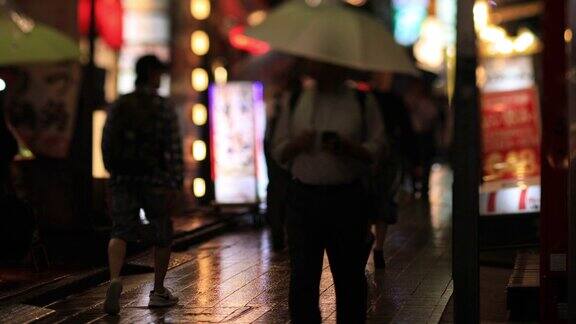 在东京中野的雨天在繁华的霓虹街上行走的人们