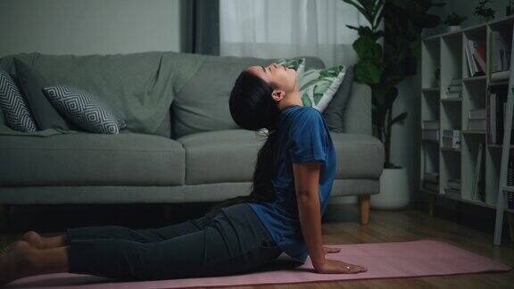 年轻的单身女性在地板上做伸展瑜伽练习
