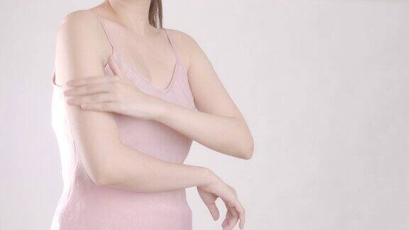 亚洲成年女性用手在肩膀上涂抹保湿霜身体保健
