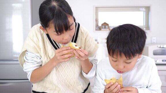 亚洲姐妹和兄弟吃自制的可丽饼当零食