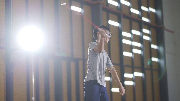 亚洲华人少年在羽毛球场上练习