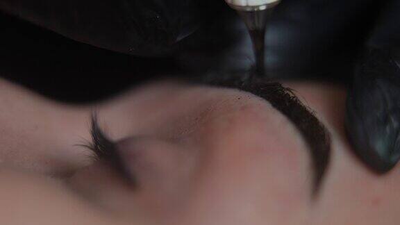 微刀片眉毛在美容院的慢动作特写纹身师的手注射永久化妆色素在面部皮肤与纹身机作为现场摄像机移动左到眼睛