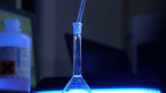 科学家用注射器将透明液体倒入试管中