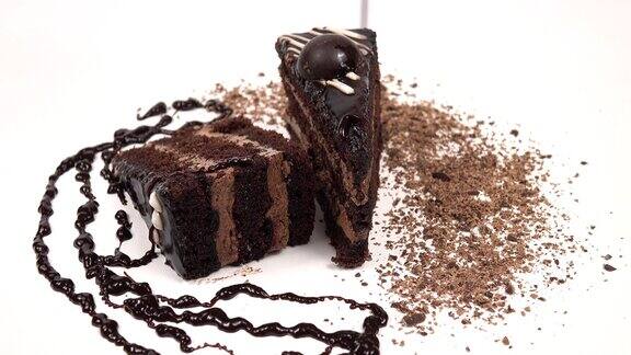 白色盘子的背景是一块巧克力蛋糕上面有巧克力奶油和巧克力酱