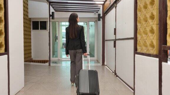 后景亚洲商务女性慢动作走在酒店与行李慢动作商务旅行