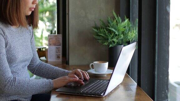 女人用她的笔记本电脑在咖啡馆放松时间摄影