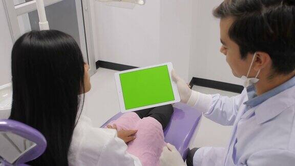 牙医用绿屏片向病人讲解手术步骤