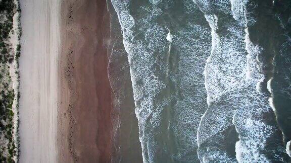 从上往下看海浪冲击着沙滩