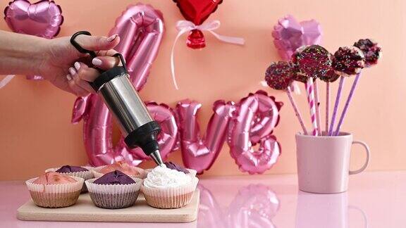 用白色奶油装饰可爱的特别的粉色和紫色杯子蛋糕为情人节做甜点