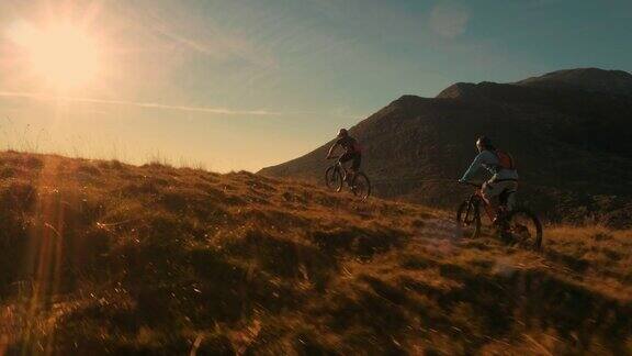 山地自行车手在令人惊叹的夕阳下越野
