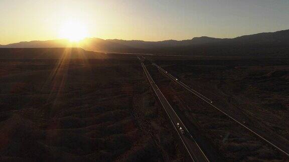 鸟瞰图的日出之间的高速公路之间的桌山附近的Mesquite内华达州美国在早春汽车和卡车很少来往无人机4K超高清视频与上升相机运动