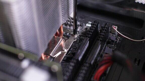 近距离高角度视图无法识别的修理工从主板上拧下固定PCCPU空气冷却系统组件散热器的螺钉