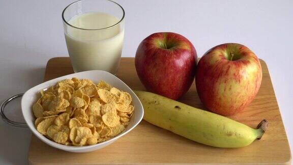 早餐是牛奶、苹果、香蕉和玉米片