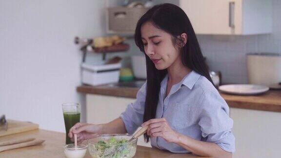 健康的亚洲妇女在家里的厨房里混合准备烹饪蔬菜沙拉素食主义者的素食概念