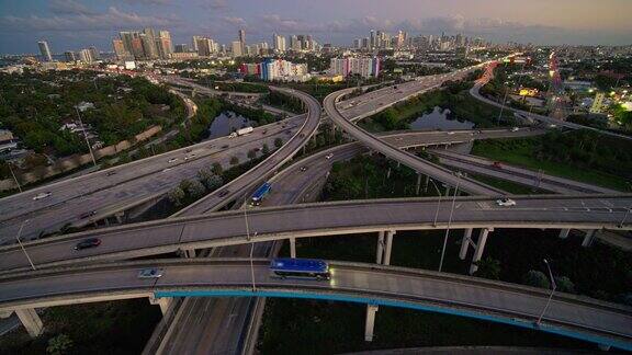 大而繁忙的高架交通枢纽95州际公路和I-195在北迈阿密与设计区和迈阿密市中心的远景日落时用超宽镜头无人机制作的b-roll镜头与静态摄像机