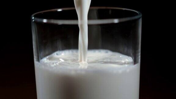 把牛奶倒进玻璃杯里