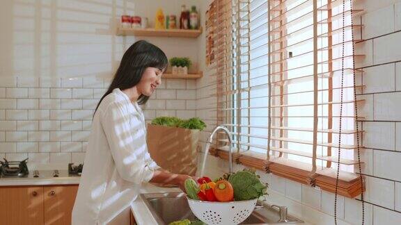 亚洲妇女在厨房里洗菜