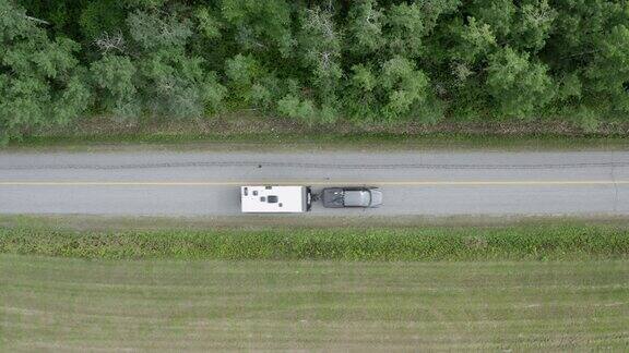 鸟瞰图一辆卡车拉一个露营拖车在乡村道路上