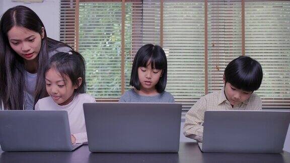 快乐的孩子们在课外课堂上使用笔记本电脑学习编程在科技课上老师向学生展示笔记本电脑上的信息回到学校教育技术儿童科学和人女性在干