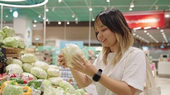 一位女士在超市挑选蔬菜