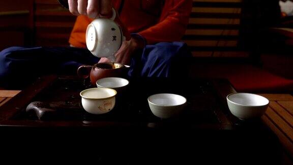 在中国传统茶道上一名男子用茶壶倒普洱茶一套饮茶设备