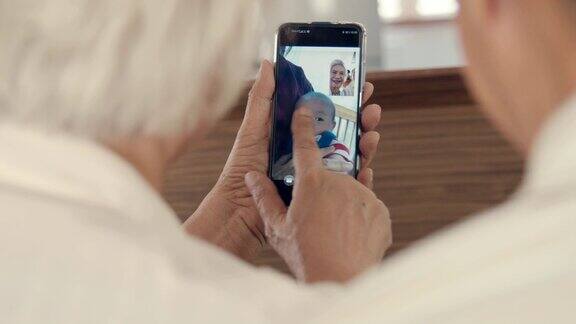 爷爷奶奶在家里用智能手机和孙子聊天