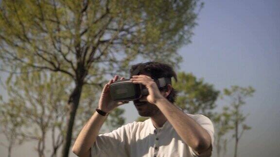 年轻人在虚拟现实头盔或VR眼镜户外