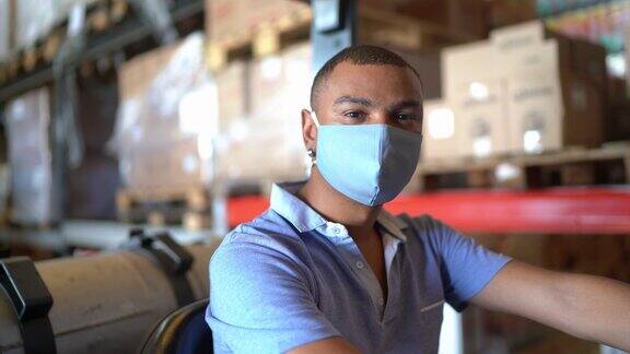 一个戴着面罩的男人在配送仓库里喝着叉车