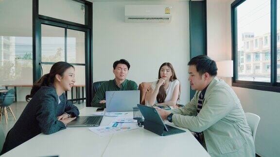 一群亚洲办公室职员在会议室分享新业务项目的想法