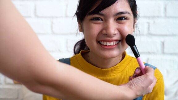 化妆师为年轻的亚洲少女化妆