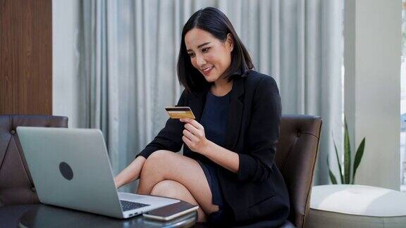 亚洲商务女性在明亮的休息区使用笔记本电脑