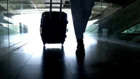一个商人带着手提箱在机场的剪影