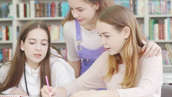 三个十几岁的女孩一起在图书馆学习