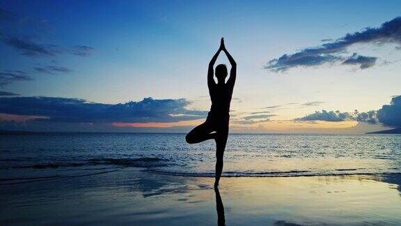 在日落练习瑜伽的女人