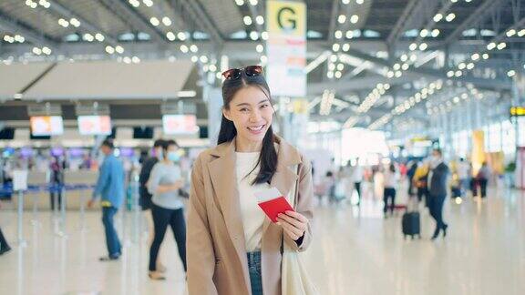 亚洲年轻女孩的肖像走在机场航站楼到登机门迷人美丽的女游客旅客感到快乐和兴奋去国外旅游的飞机假期旅行